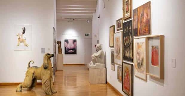 Galería interior con esculturas y obras de arte en las paredes