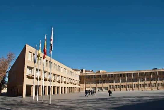Fachada principal del Ayuntamiento de Logroño con banderas ondeando bajo cielo azul despejado