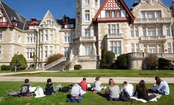 Vista frontal del Palacio de la Magdalena con estudiantes en el césped