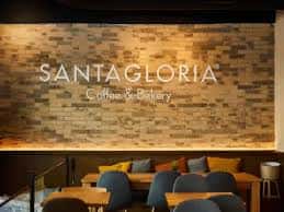 Pared de ladrillo con el logo de Santagloria iluminado