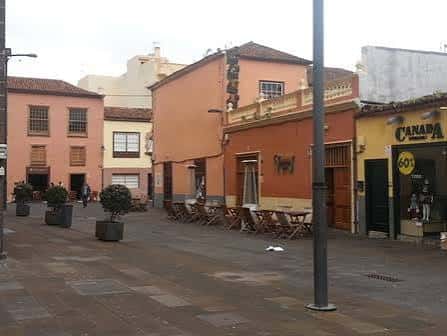 Vista de la plaza con edificios coloridos y mesas de cafetería al aire libre