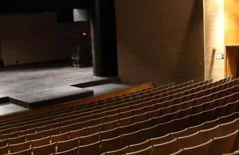 Vista del interior del auditorio con butacas y escenario vacío