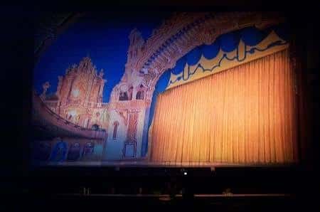 Escenario con telón dorado y decoración de fondo pintada