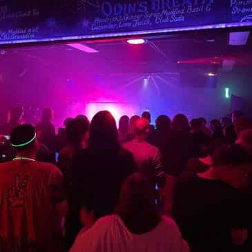 Público disfrutando de la música en el interior del Crow Bar con luces de neón