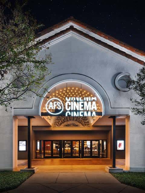 Fachada nocturna del AFS Cinema con letrero iluminado y arquitectura clásica