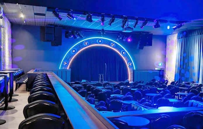 Vista del escenario y las butacas del Comedy Mothership con iluminación azul