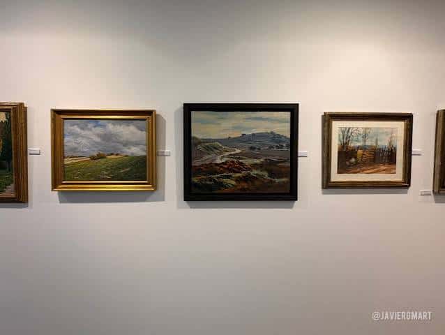 Pared de la galería con cuadros de paisajes enmarcados