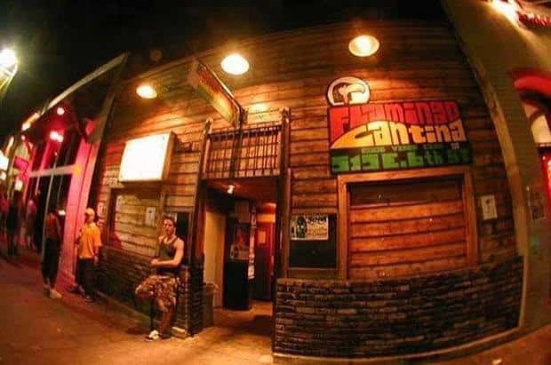Vista exterior nocturna de Flamingo Cantina con su letrero iluminado en 6th Street