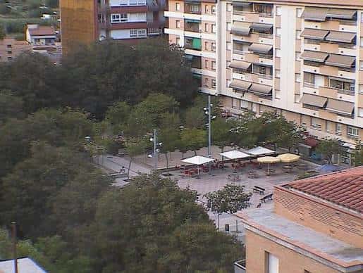 Vista panorámica de la Plaça de Santa Eugènia con mesas y sombrillas