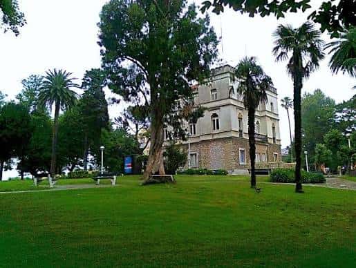 Vista general del edificio principal del Parque Jado rodeado de jardines y palmeras