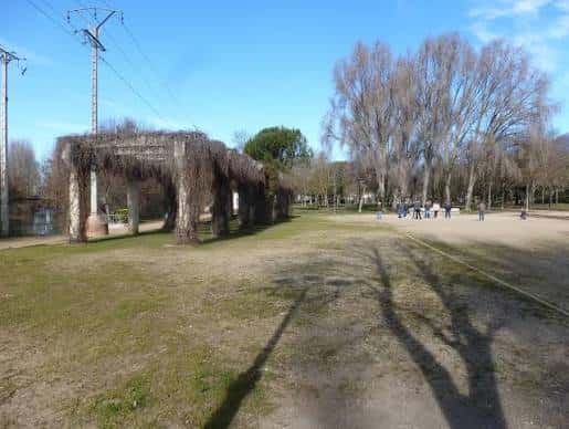 Área verde de las Huertas del Obispo con pérgola y árboles en invierno
