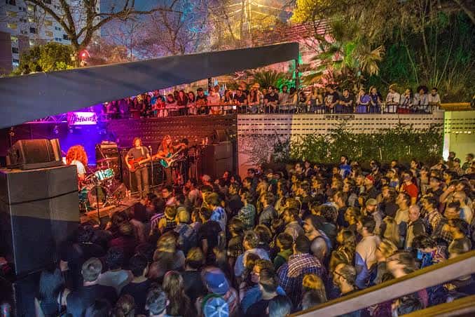 Concierto en vivo en el patio exterior del Mohawk Austin con público y banda en el escenario