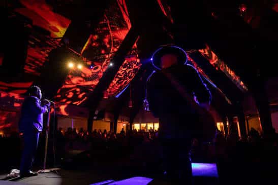 Concierto en vivo en el 04 Center con iluminación dramática y público en el escenario
