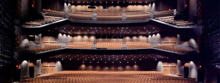 Vista panorámica del interior del auditorio con múltiples niveles de butacas y escenario iluminado