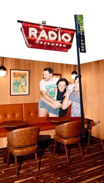 Interior acogedor con sillones de cuero, mesa redonda y cartel de Radio Rosewood