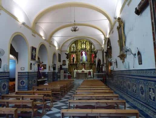 Interior de la capilla con nave central, bancos y altar mayor