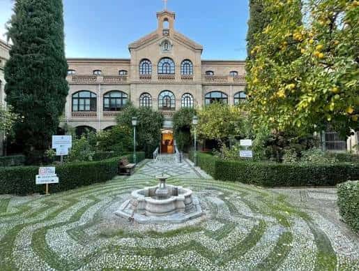 Jardín central con fuente y sendero que conduce a la entrada del centro cultural