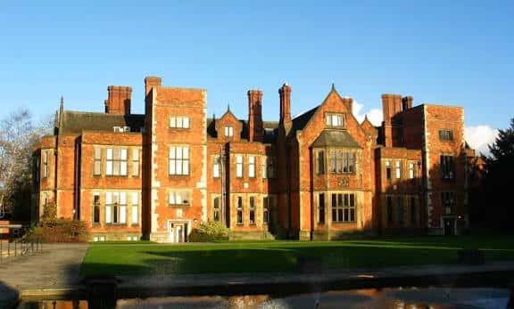 Heslington Hall al atardecer con reflejo en el estanque delantero