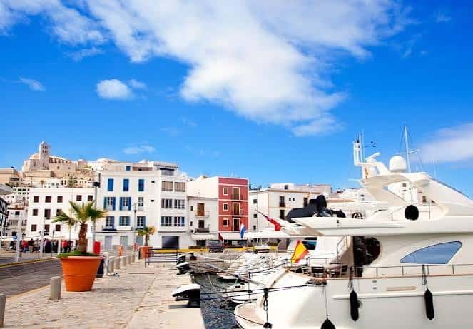 Puerto de Ibiza con yates y edificios blancos bajo cielo azul