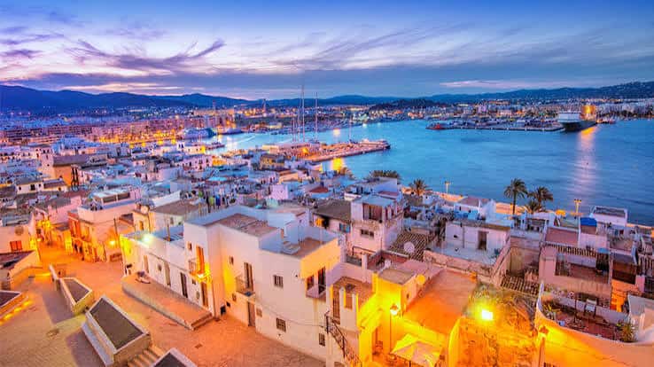 Vista panorámica del puerto de Ibiza al atardecer con luces encendidas