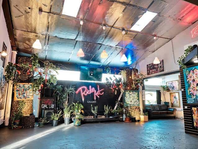 Interior del RichesArt Gallery con iluminación de neón y decoración artística