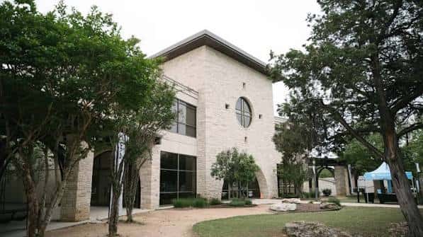 Edificio de piedra de The Austin Stone rodeado de árboles y con entrada arqueada