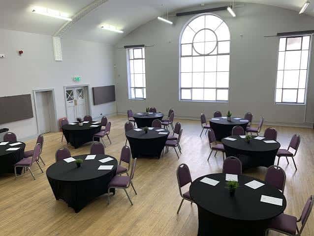 Interior del Small Hall configurado para un evento con mesas redondas y sillas