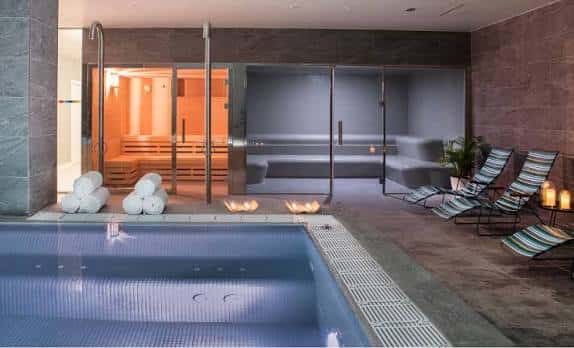 Interior del spa del hotel con piscina, sauna y zona de relax con tumbonas