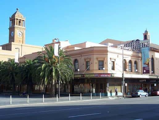 Fachada exterior del Civic Theatre Newcastle con palmeras y cielo despejado
