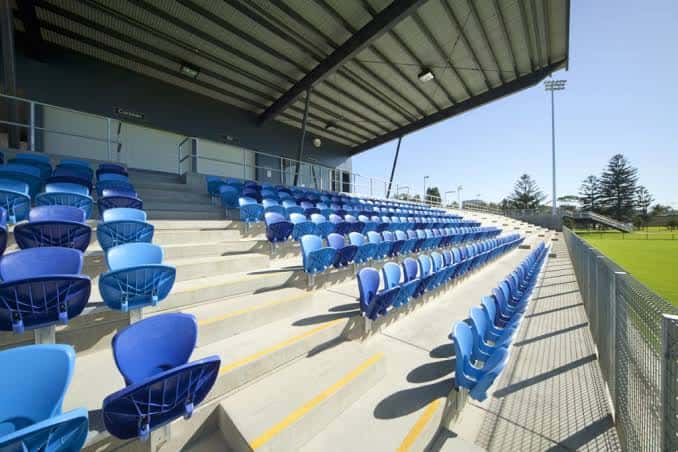 Detalle de las gradas con asientos azules bajo el techo del estadio