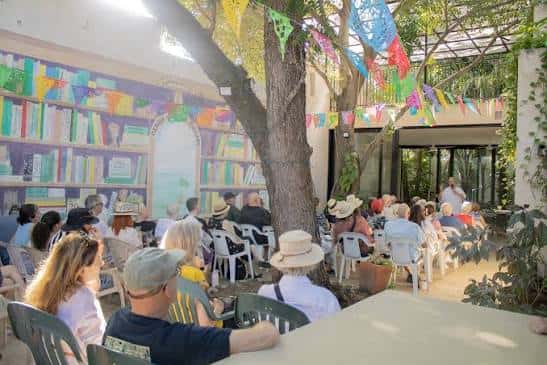 Evento comunitario en el patio de la biblioteca con decoración festiva