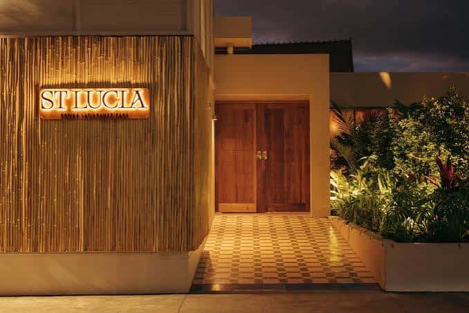 Entrada nocturna del restaurante St Lucia con fachada de bambú iluminada