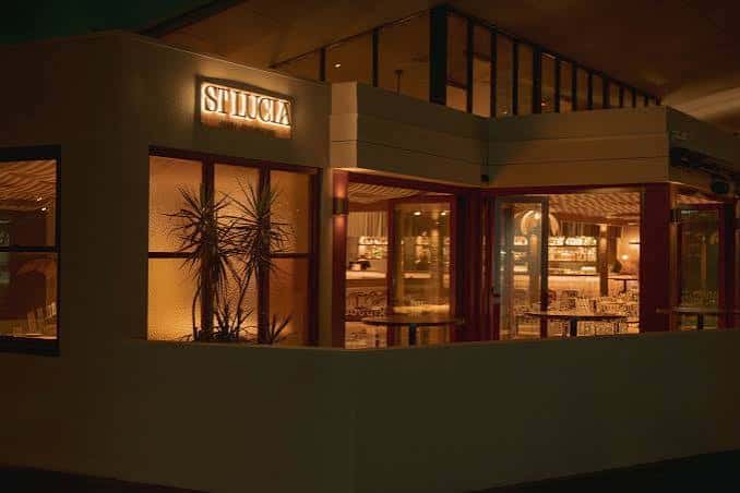 Vista exterior del restaurante St Lucia por la noche con ventanas iluminadas