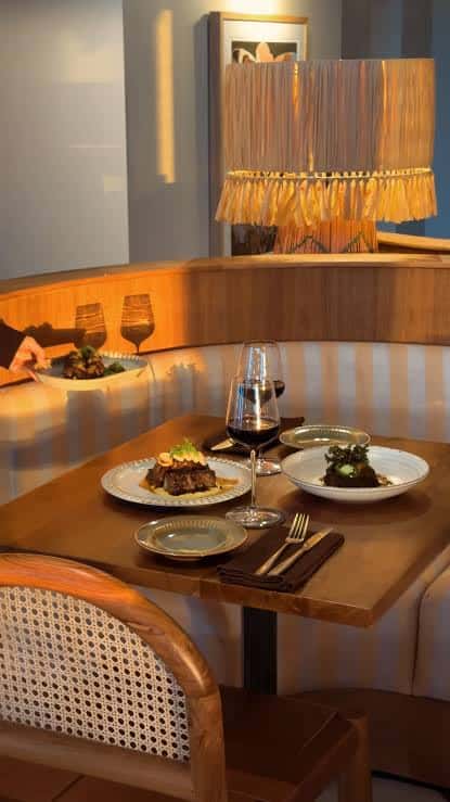 Mesa servida en el interior del restaurante con platos gourmet y vino tinto