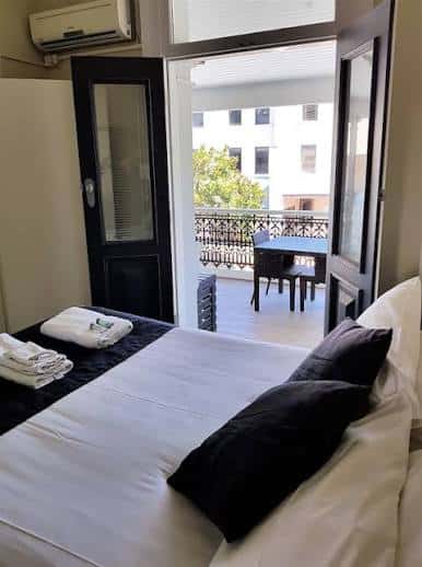 Habitación del Grand Hotel con cama, toallas y balcón con vistas a la ciudad