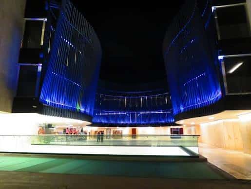 Vista nocturna del Palacio de la Música con fachada iluminada en azul