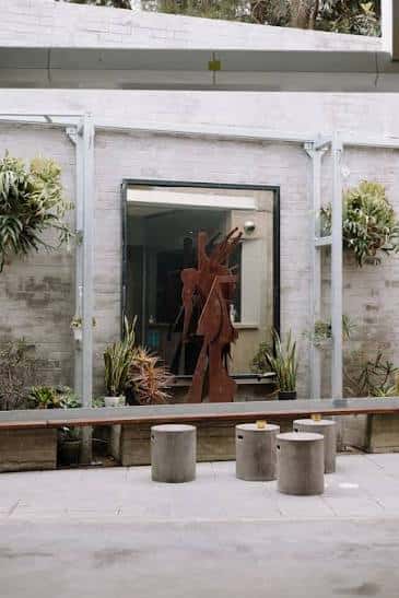 Área de patio exterior de Straitjacket con escultura y asientos