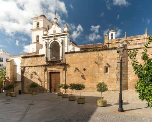 Vista exterior de la Concatedral de Santa María en Mérida con cielo azul y jardines