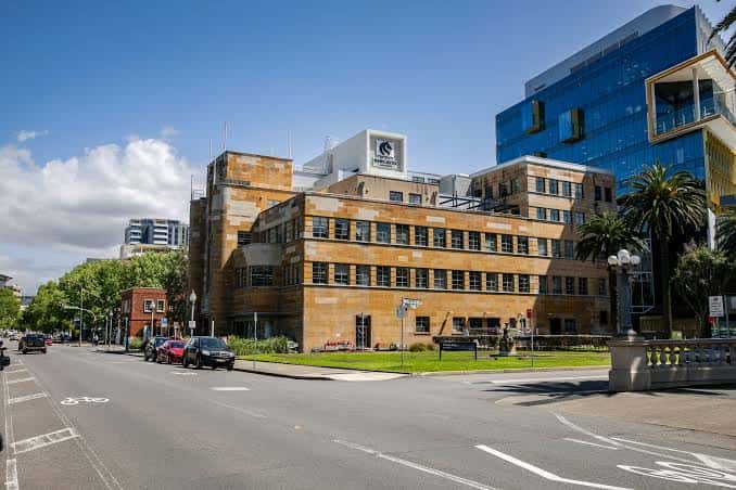 Vista panorámica de University House en Newcastle con fachada de piedra arenisca y cielo azul