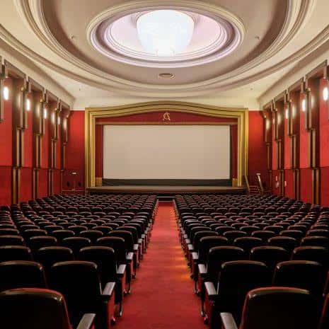 Interior del auditorio principal con butacas rojas y pantalla grande