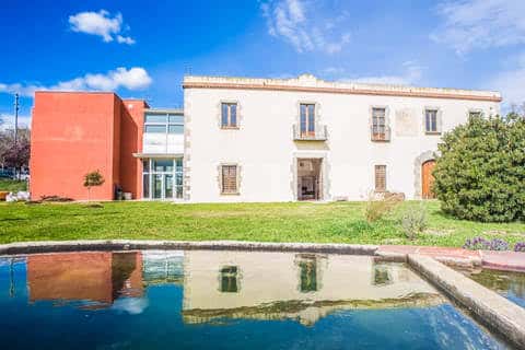 Vista exterior de Can Boet con fachada histórica y jardín mediterráneo