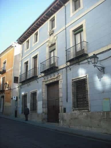 Vista exterior del edificio histórico bajo luz diurna, mostrando su entrada monumental y ventanas con rejas