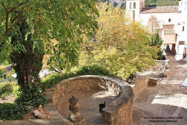 Plaza con fuente circular y árboles en el barrio de San Miguel