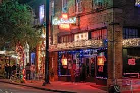 Fachada nocturna del The Continental Club con iluminación de neón