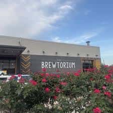 Fachada del Brewtorium con jardín de rosas al frente