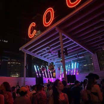 Vista nocturna de la terraza con iluminación neón y ambiente festivo