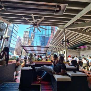 Terraza diurna del Coconut Club con vistas a la ciudad y clientes relajados