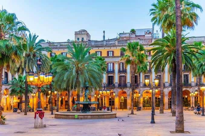 Atardecer en la Plaza Real con farolas encendidas y ambiente festivo
