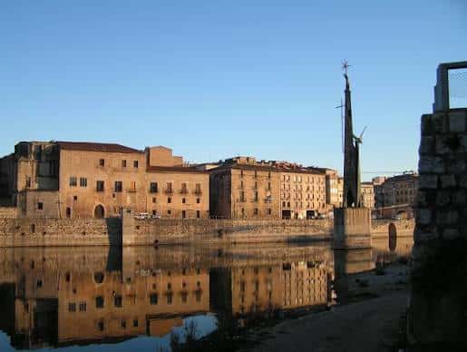 Vista panorámica del Palau Episcopal desde la orilla del río al atardecer