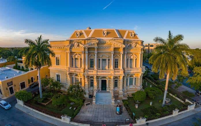 Vista aérea del Palacio Cantón al atardecer con jardines bien cuidados